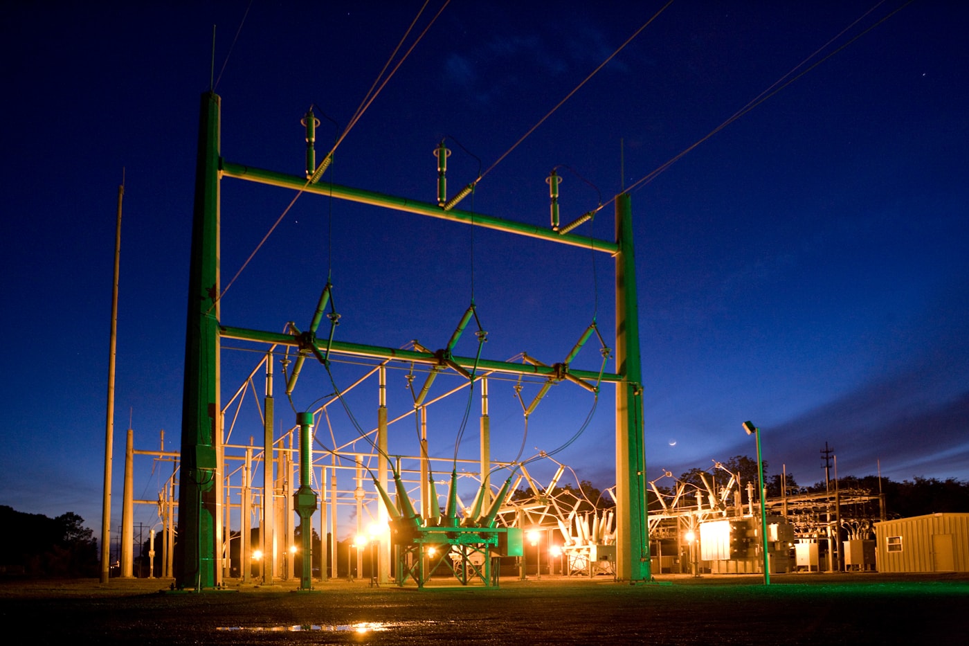 High-voltage transmission lines and towers against an open sky.