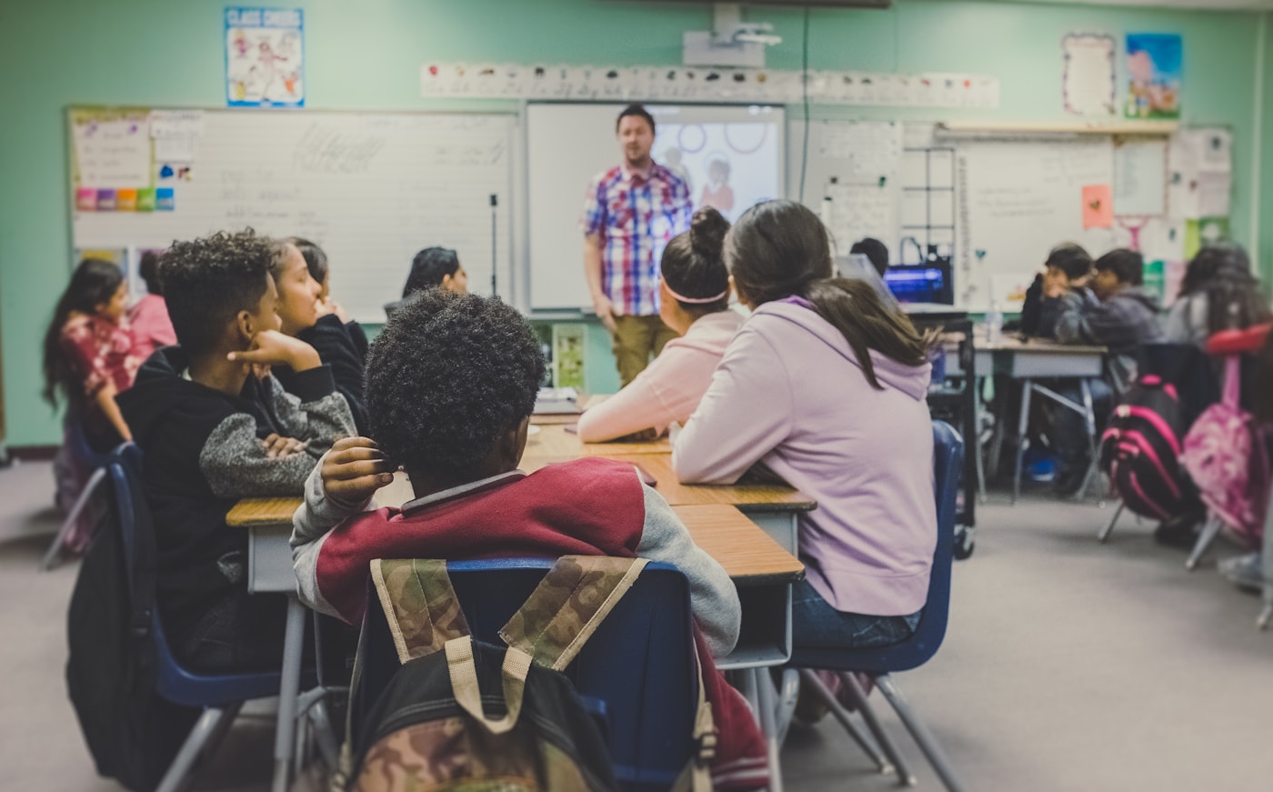 Students and a teacher using technology in a classroom.