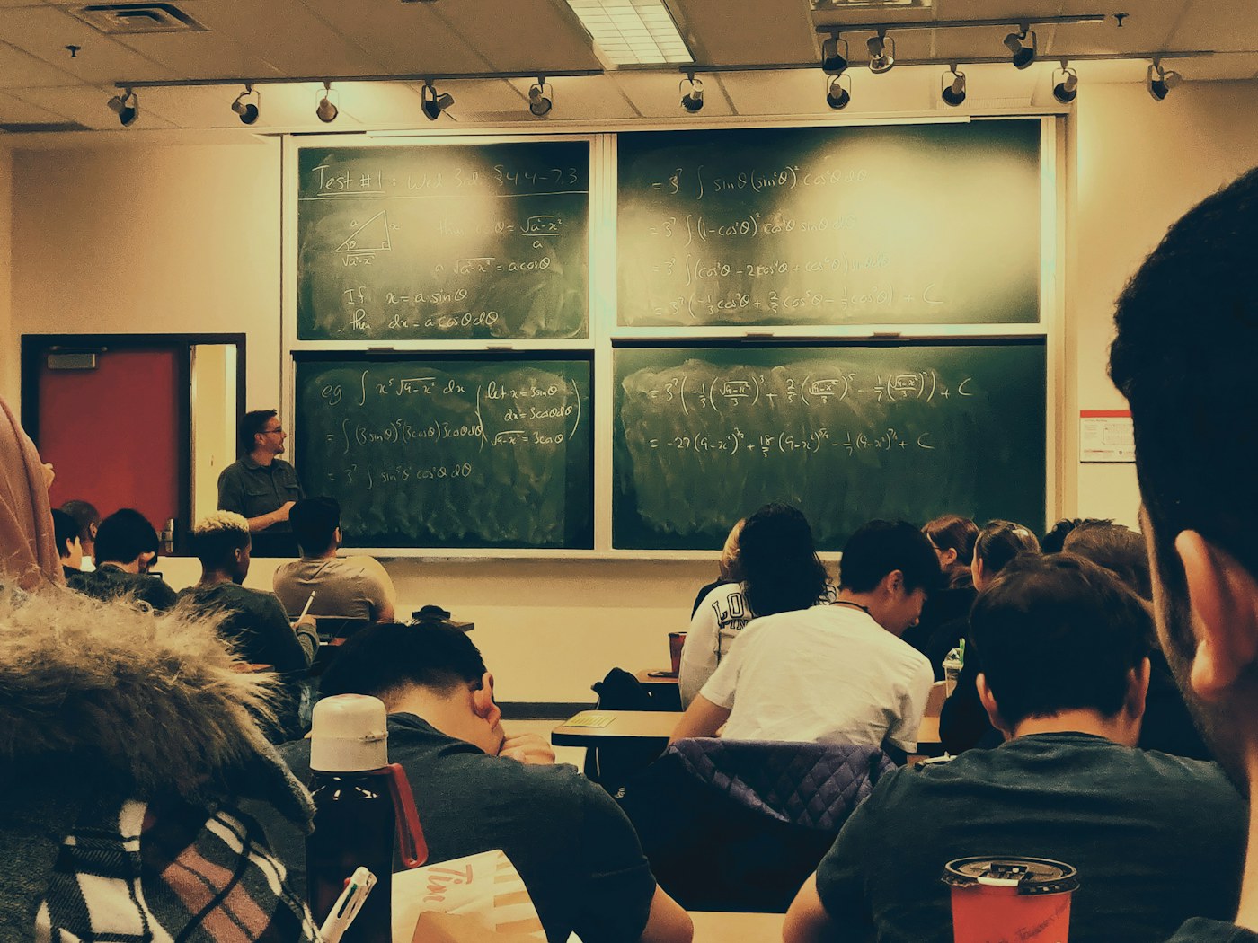 Teacher working alongside students using AI tutoring tools in a classroom