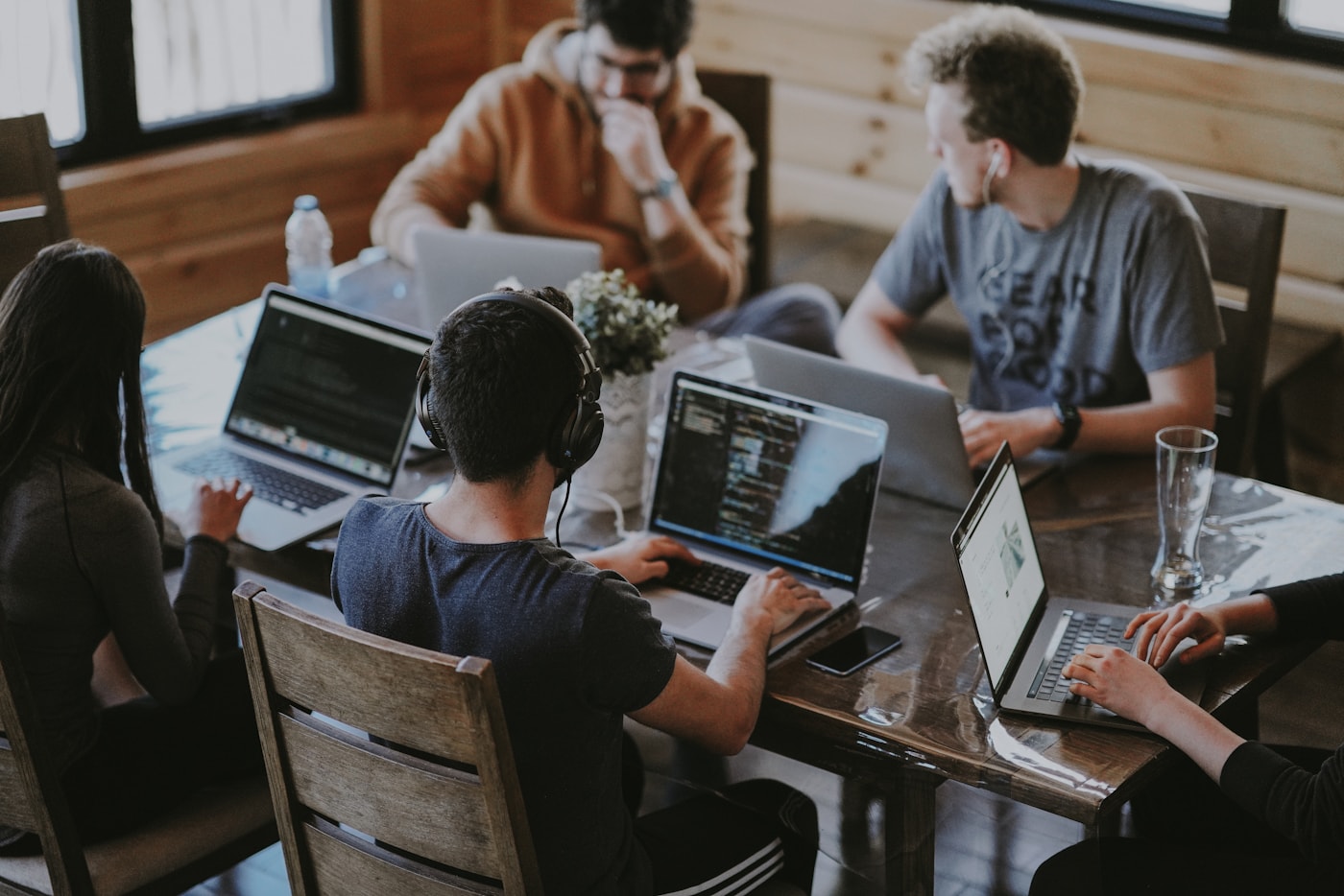 A team collaborating around laptops in a modern office.